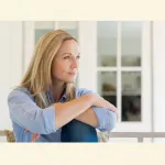 Nachdenkliche Frau als Symbol für die tiefe Wirkung belastender Erfahrungen