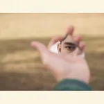 Mann betrachtet sein Auge im Spiegel als Symbol für Selbstwahrnehmung und inneren Zustand