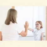 Kind berührt das erwachsene Ich im Spiegel als Symbol für Vergangenheit, Gegenwart und innere Erinnerung